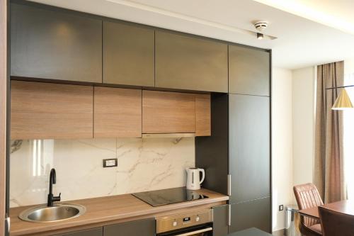 a kitchen with wooden cabinets and a sink at Vila Golija in Kopaonik