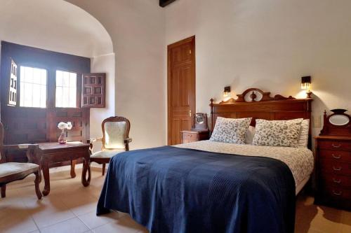 a bedroom with a large bed and a chair at Posada La Judería I in Córdoba