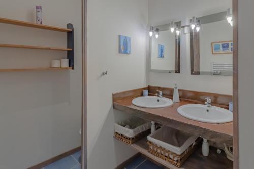 łazienka z 2 umywalkami i lustrem w obiekcie Gite Beynac w mieście Sainte-Mondane