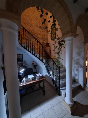 Zimmer mit einer Treppe, einem Schreibtisch und einem Tisch in der Unterkunft Hostal Fenix in Jerez de la Frontera