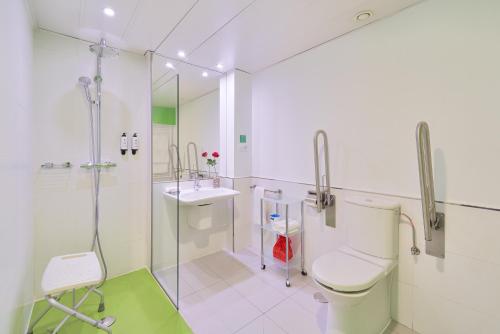 a bathroom with a shower and a toilet and a sink at Blume Cruz Suites in Madrid