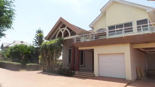 una casa con un garaje delante en Ypool Pacific Homes, en Kumasi