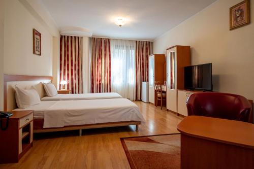 a hotel room with a bed and a flat screen tv at Primavera 1 Hotel in Pazardzhik