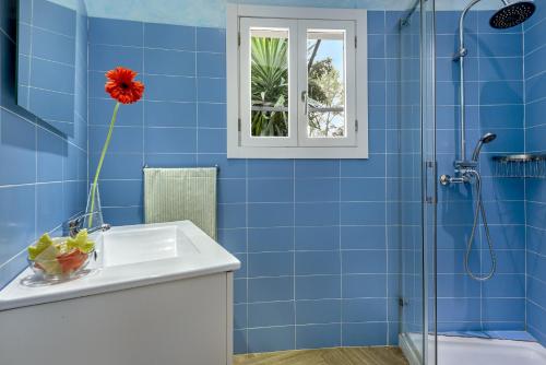 een blauwe badkamer met een wastafel en een douche bij Ideal house with garden and private swimming pool in a quiet urbanization in Sa Pobla