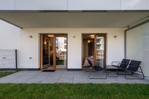 a patio with chairs and a table in front of a building at RentPlanet - Apartamenty Zakopiańskie in Zakopane