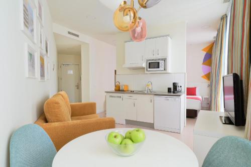 a kitchen with a table with a bowl of apples on it at Blume Cruz Suites in Madrid