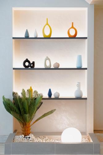 a shelf filled with vases and a plant at Buri Sriphu Hotel in Hat Yai