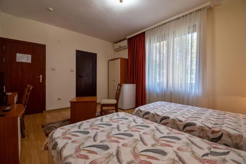 a hotel room with two beds and a window at Primavera 1 Hotel in Pazardzhik