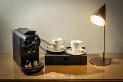a coffee maker and two cups on a table at Best Western Plus Hotel De La Regate-Erdre in Nantes