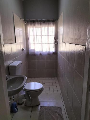 a bathroom with a toilet and a sink at Gqeberha Self Catering Apartments in Kensington