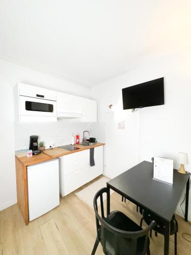 une cuisine avec un bureau et une table avec une chaise dans l'établissement Balisier Studio avenue de Lodève, à Montpellier