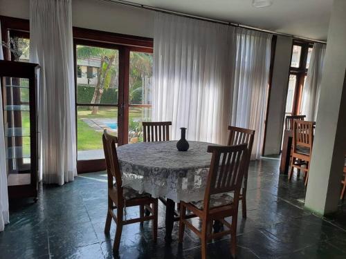 a dining room table with chairs and a vase on it at Praia Itacoatiara Casa Jardim in Niterói