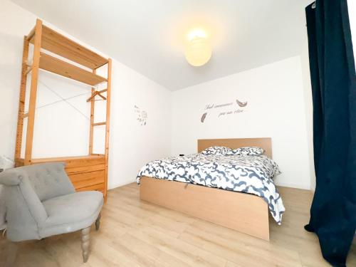 une chambre avec un lit, une chaise et un miroir dans l'établissement Bégonias Appartement T3 Avenue de Lodève, à Montpellier