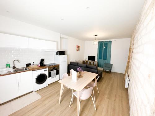 une cuisine et un salon avec une table et un évier dans l'établissement Bégonias Appartement T3 Avenue de Lodève, à Montpellier