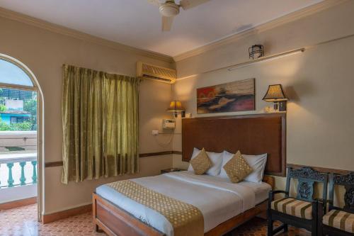 a hotel room with a bed and a window at La Ben Resort in Colva