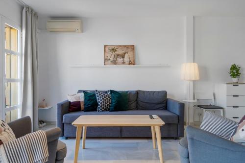 uma sala de estar com um sofá azul e uma mesa em Easy apartment in Fuengirola Downtown - Ref 28 em Fuengirola