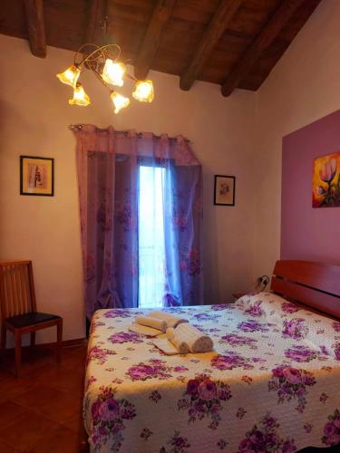 a bedroom with a bed with a floral bedspread at B&B Mannalà in Agrigento
