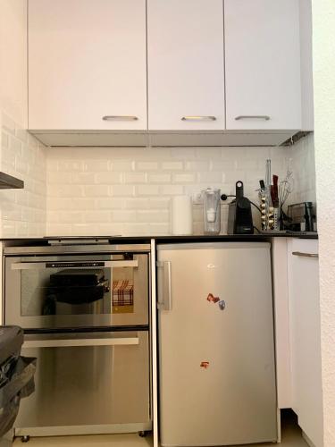 伊索拉 2000的住宿－Studio montagne gentianes，厨房配有白色橱柜和冰箱。