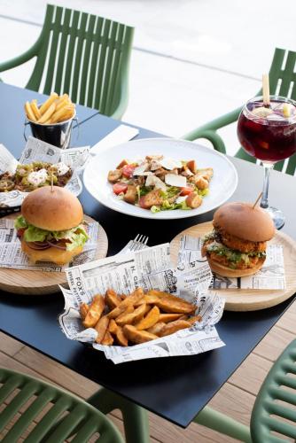 a table topped with plates of food and french fries at Ibiza Rocks Hotel - Adults Only in San Antonio