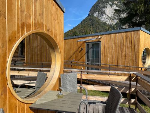 Unique Tiny Eco Lodges with gorgeous views to Jungfrau Massiv في إنترلاكن: مبنى خشبي مع طاولة وكراسي