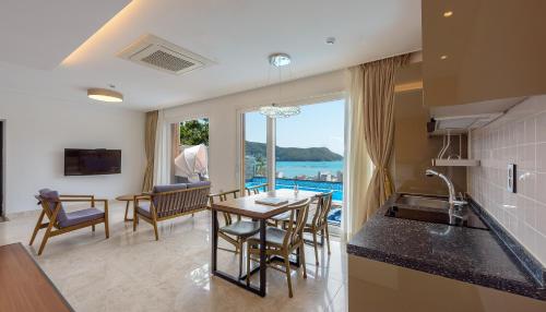 cocina y sala de estar con mesa y vistas en Friemily Pool Villa & Hotel, en Geoje