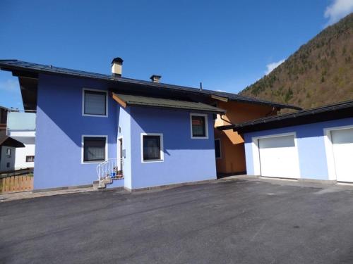 a blue and white building with a parking lot at Ferienwohnung Astl in Kirchdorf in Tirol