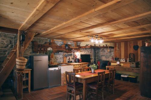 uma cozinha com uma mesa e um frigorífico em La Taverna dei Due Gufi em Saint-Rhémy-en-bosses