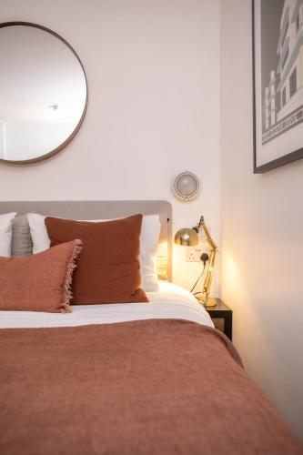 a bedroom with a bed with a mirror on the wall at The Luxury Inn in London