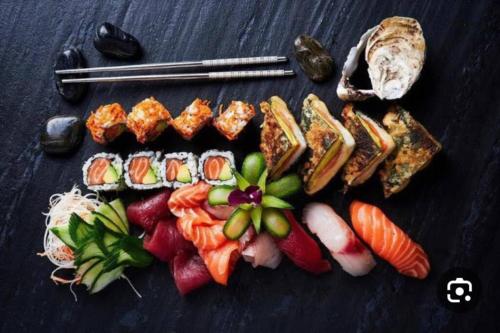 a plate of food with sushi and chopsticks on a table at the pool on the sea in Netanya