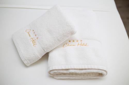 a white towel with the words queen hill on it at Charm Hotel in Vlorë
