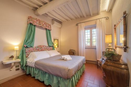 a bedroom with a bed with a green canopy at Casamaggio in San Donato in Collina