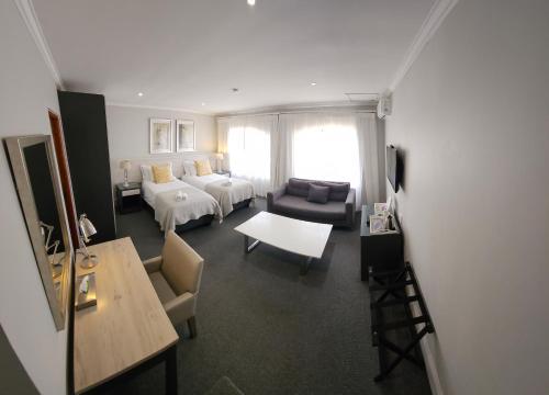 a living room with two beds and a couch at Villa Tuscana in Port Elizabeth