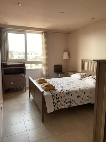 une chambre avec un lit, un bureau et une fenêtre dans l'établissement Charmant appartement 3 pièces avec balcon (équipé PMR), à Montrouge