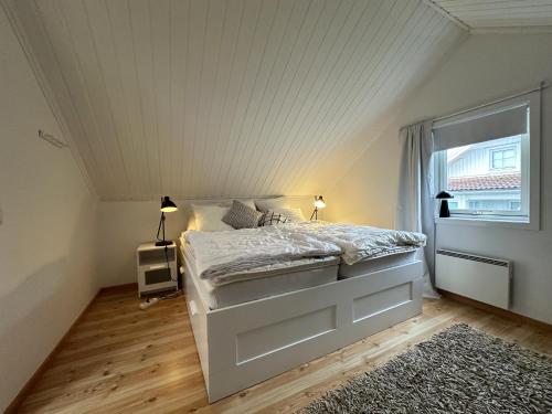 - une chambre avec un lit blanc et une fenêtre dans l'établissement Modern and cozy cottage near beautiful Fjallbacka, à Fjällbacka