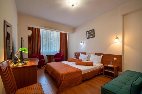 a hotel room with a bed and a couch at Primavera 2 Hotel in Pazardzhik