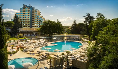 a view of a pool with umbrellas and a building at Valamar Diamant Residence in Poreč