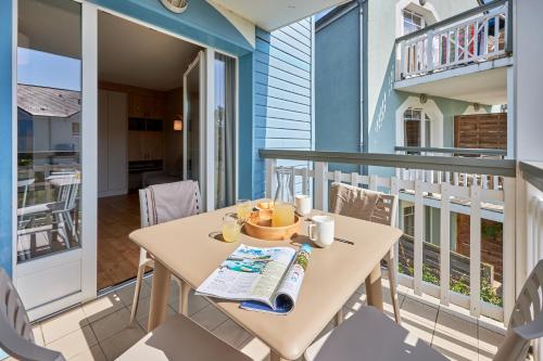 a balcony with a table and chairs on a balcony at Pierre & Vacances Résidence Le Chant des Oiseaux in Courseulles-sur-Mer