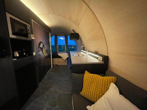 um quarto com um sofá e um lavatório num quarto em Ontspan in de Droomstam em Dalfsen