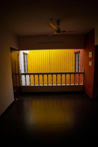 an empty room with a yellow door and a balcony at Wetzlar Villas in Angamaly