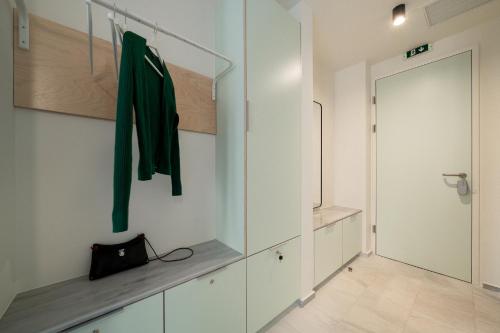 a hallway with white cabinets and a green jacket at Mooeve Exarchia in Athens
