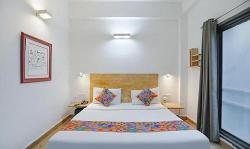 - une chambre avec un grand lit et une fenêtre dans l'établissement FabHotel F9 Sector 51, à Noida