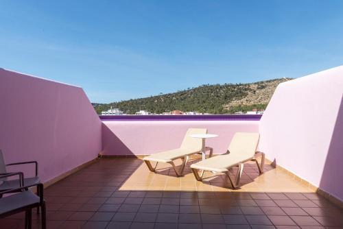 a balcony with two chairs and a table on a roof at Ibiza Rocks Hotel - Adults Only in San Antonio