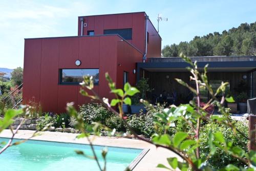 a red house with a swimming pool in front of it at nature in Gardanne