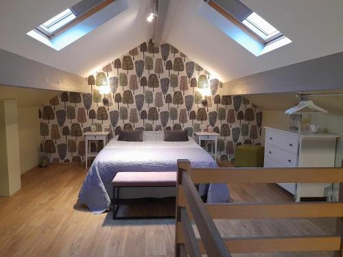 um quarto com uma cama num quarto com clarabóias em Le Cerf volant em Libin