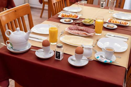 a table with eggs on plates and cups of juice at Primavera 1 Hotel in Pazardzhik