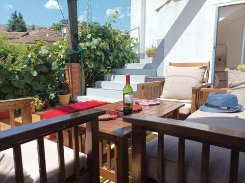 eine Terrasse mit einem Tisch und einer Flasche Wein in der Unterkunft Casa rural Aloha Vera in Jarandilla de la Vera