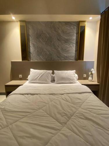 ein großes weißes Bett mit zwei Kissen im Schlafzimmer in der Unterkunft Luxury Studio Benson Apartment, Pakuwon Mall in Surabaya