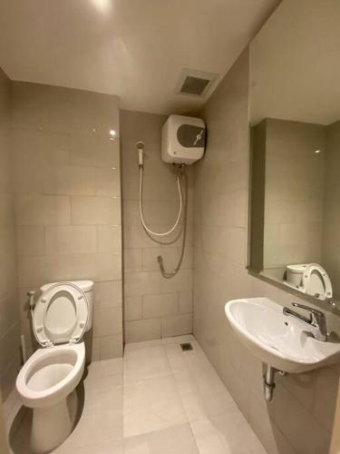 a bathroom with a toilet and a sink at Luxury Studio Benson Apartment, Pakuwon Mall in Surabaya