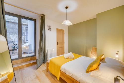 une chambre avec un lit et une grande fenêtre dans l'établissement Les Capucines - Bel appt en centre-ville, à Bordeaux