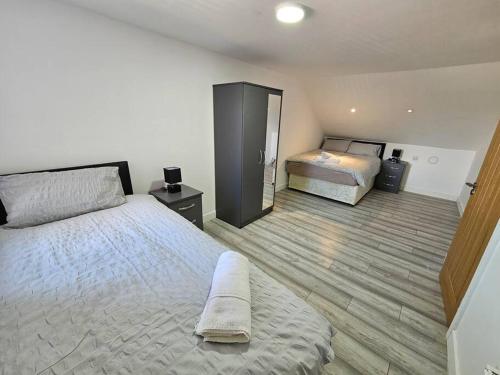 a bedroom with a large bed and a mirror at LUXE Villa Near NEC, BHX & Train in Birmingham